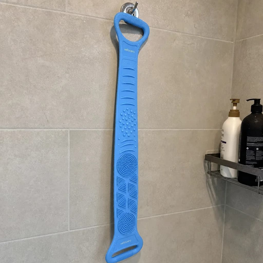 Cepillo Vellocero colgado en la pared de la ducha